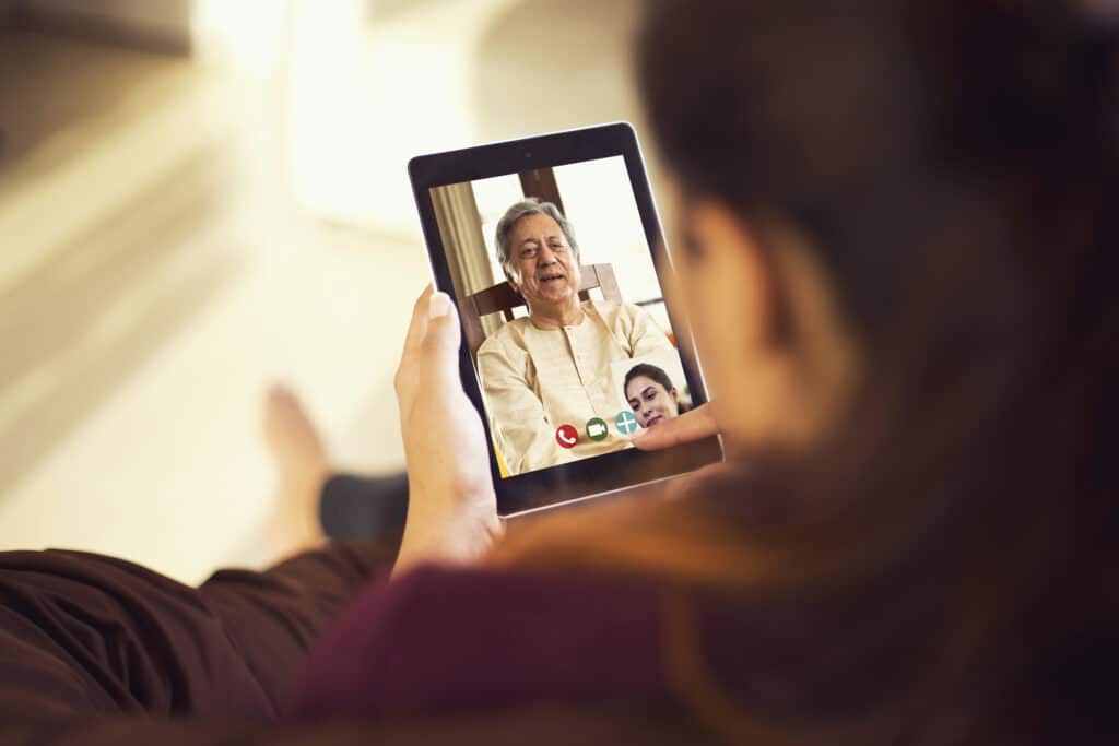 Daughter talking on video call with her father using digital tablet